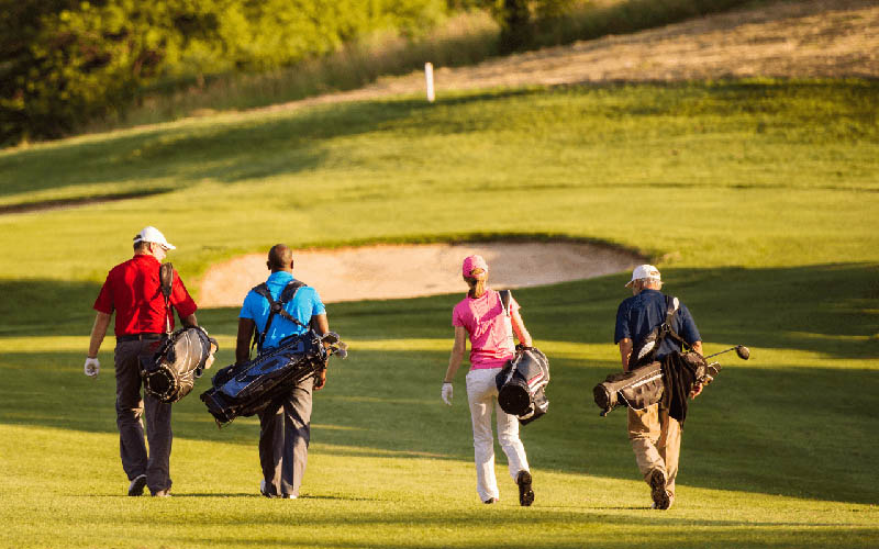 Golf club members walking across the fairway, representing how golf management software enhances member experiences with scheduling, billing, and POS features.
